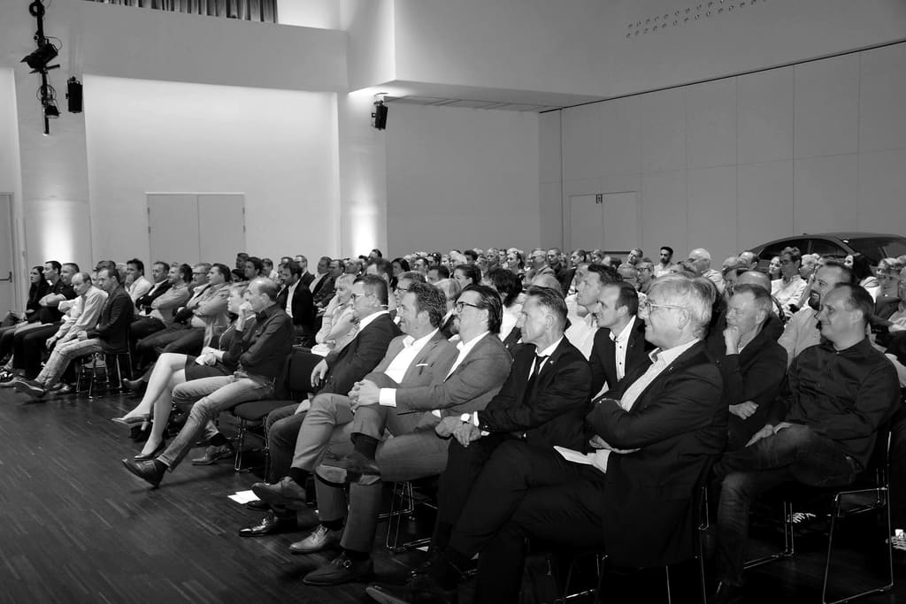 Blick in das Publikum während eines Vortrags, Aufnahme in Schwarz und Weiß.