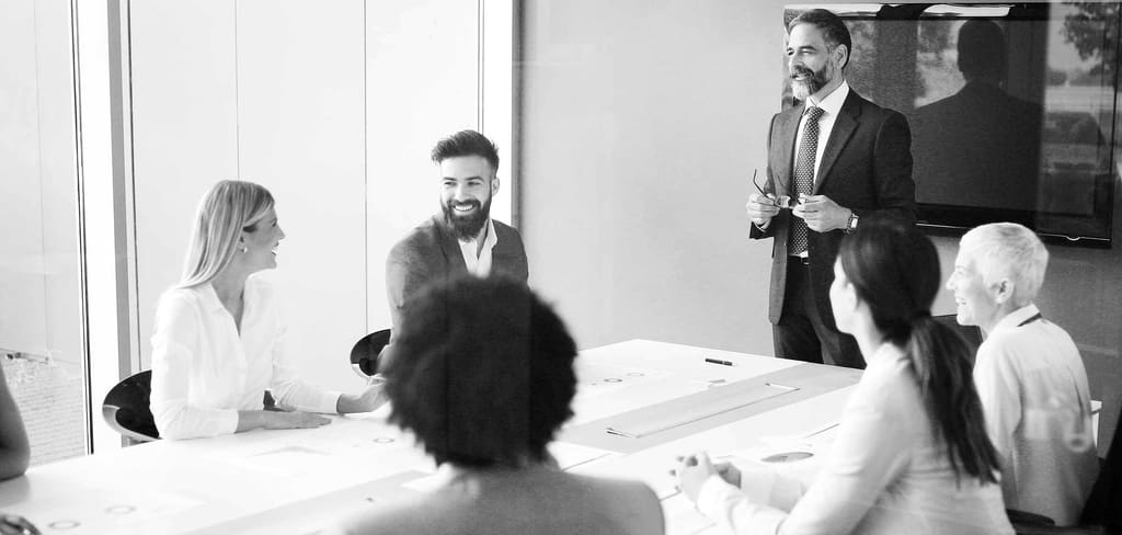 Geschäftsleute in einer Besprechung in einem modernen Büro, Aufnahme in Schwarz und Weiß.